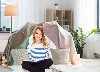 Image showing happy smiling girl reading book at home
