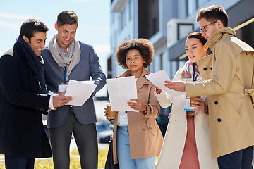 Image showing international business team with papers outdoors