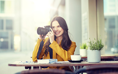 Image showing happy tourist woman with camera at city cafe