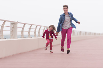 Image showing mother and cute little girl on the promenade by the sea