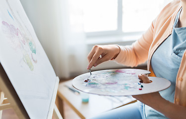 Image showing artist with palette knife painting at art studio