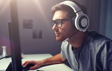 Image showing man in headset playing computer video game at home