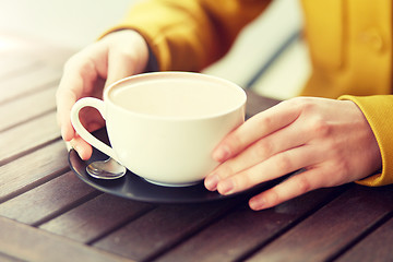 Image showing close up of woman with cocoa cup at street cafe