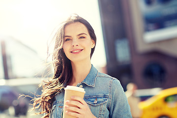 Image showing happy young woman drinking coffee on city street