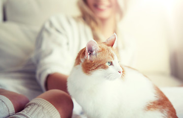 Image showing happy young woman with cat in bed at home