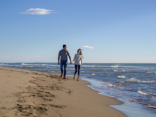 Image showing Loving young couple on a beach at autumn sunny day