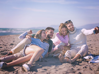 Image showing Group of friends having fun on beach during autumn day