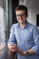 Image showing Businessman Standing In A Modern Building Near The Window With P