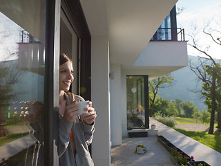 Image showing woman drinking coffee in front of her luxury home villa