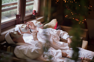 Image showing women is getting facial clay mask at spa