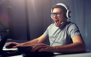 Image showing man in headset playing computer video game at home