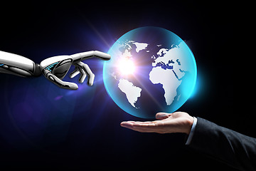 Image showing human and robot hand with virtual earth hologram