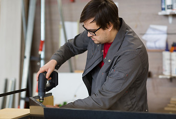 Image showing assembler with screwdriver making furniture