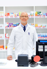 Image showing senior apothecary at pharmacy cash register