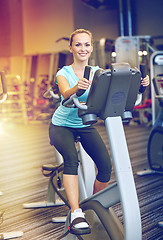 Image showing smiling woman exercising on exercise bike in gym