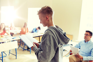 Image showing student boy with notebook and teacher at school