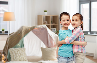 Image showing happy smiling little girls hugging at home