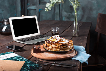 Image showing Laptop and pancakes with juice. Healthy breakfast