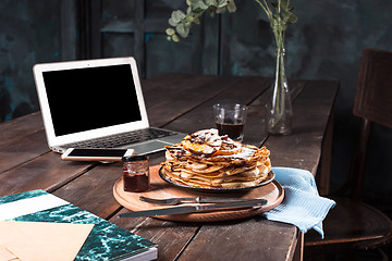 Image showing Laptop and pancakes with juice. Healthy breakfast