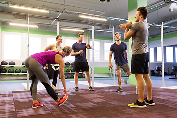 Image showing group of happy friends stretching in gym