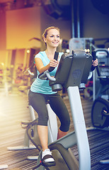 Image showing smiling woman exercising on exercise bike in gym