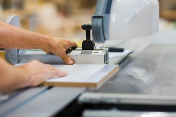 Image showing carpenter with panel saw and fibreboard at factory