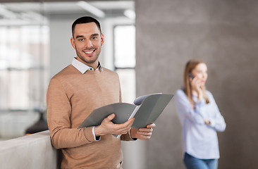 Image showing smiling male office worker with folder