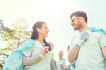 Image showing volunteers with garbage bags talking outdoors