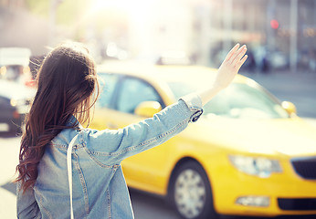 Image showing young woman or girl catching taxi on city street