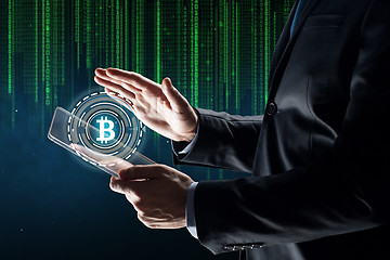 Image showing businessman with tablet pc and bitcoin hologram