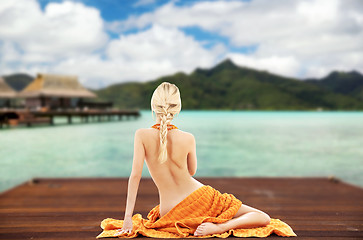 Image showing woman with towel over exotic resort background