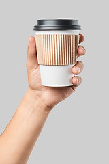 Image showing Mockup of men\'s hand holding white paper mid size cup with black cover