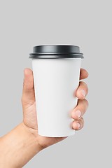 Image showing Mockup of men\'s hand holding white paper large size cup with black cover