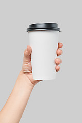 Image showing Mockup of women\'s hand holding white paper large size cup with black cover