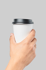 Image showing Mockup of men\'s hand holding white paper large size cup with black cover