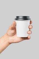 Image showing Mockup of men\'s hand holding white paper small size cup with black cover