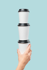 Image showing Crop hand holding stack of paper cups