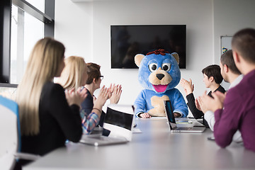 Image showing boss dresed as bear having fun with business people in trendy of