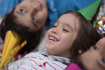 Image showing kids  blowing confetti while lying on the floor