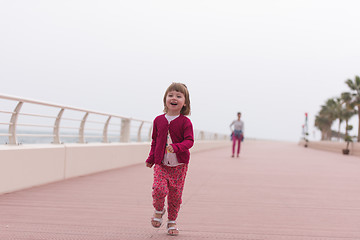 Image showing mother and cute little girl on the promenade by the sea