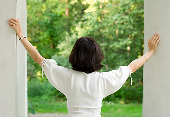 Image showing woman in white dress looking out window