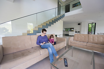 Image showing mother and her cute little daughter are using a tablet