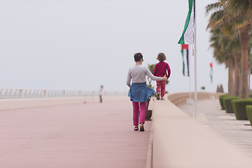 Image showing mother and cute little girl on the promenade by the sea