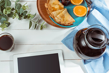 Image showing The tablet and pancakes with juice. Healthy breakfast