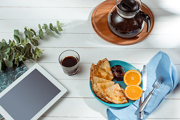 Image showing The tablet and pancakes with juice. Healthy breakfast