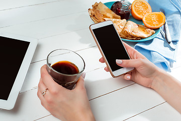 Image showing The female hands and pancakes with juice. Healthy breakfast