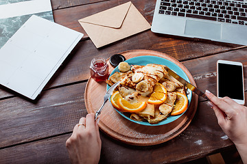 Image showing Laptop and pancakes with juice. Healthy breakfast