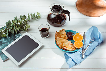 Image showing The tablet and pancakes with juice. Healthy breakfast