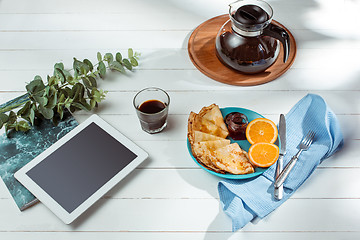 Image showing The tablet and pancakes with juice. Healthy breakfast