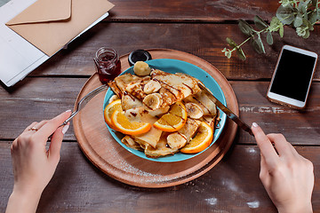 Image showing The female hands and pancakes with juice. Healthy breakfast